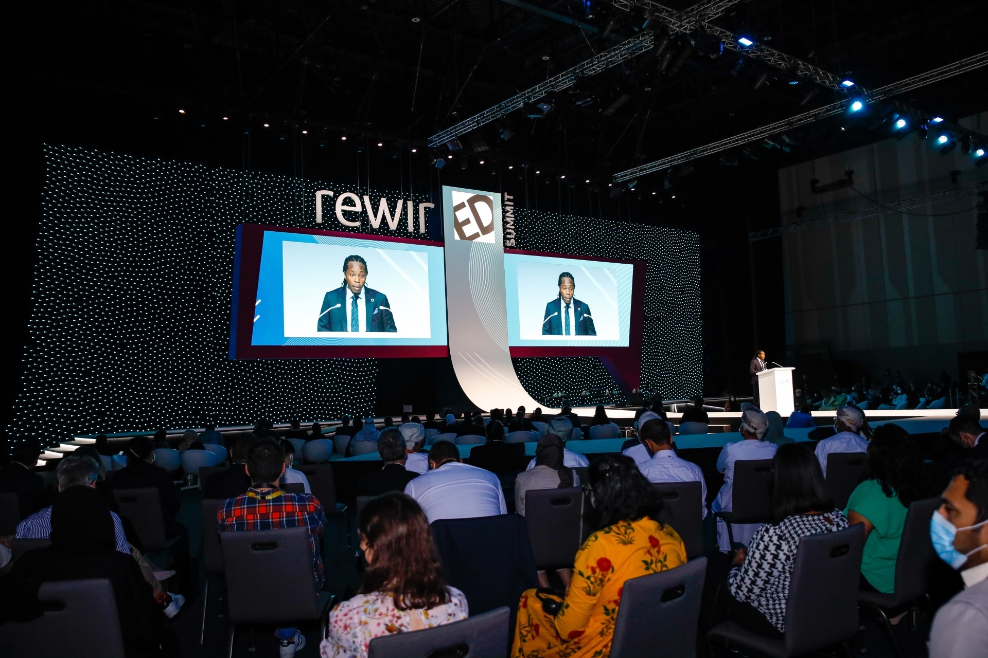 Attendees at the 2021 RewirEd Summit listening to a speaker on stage.